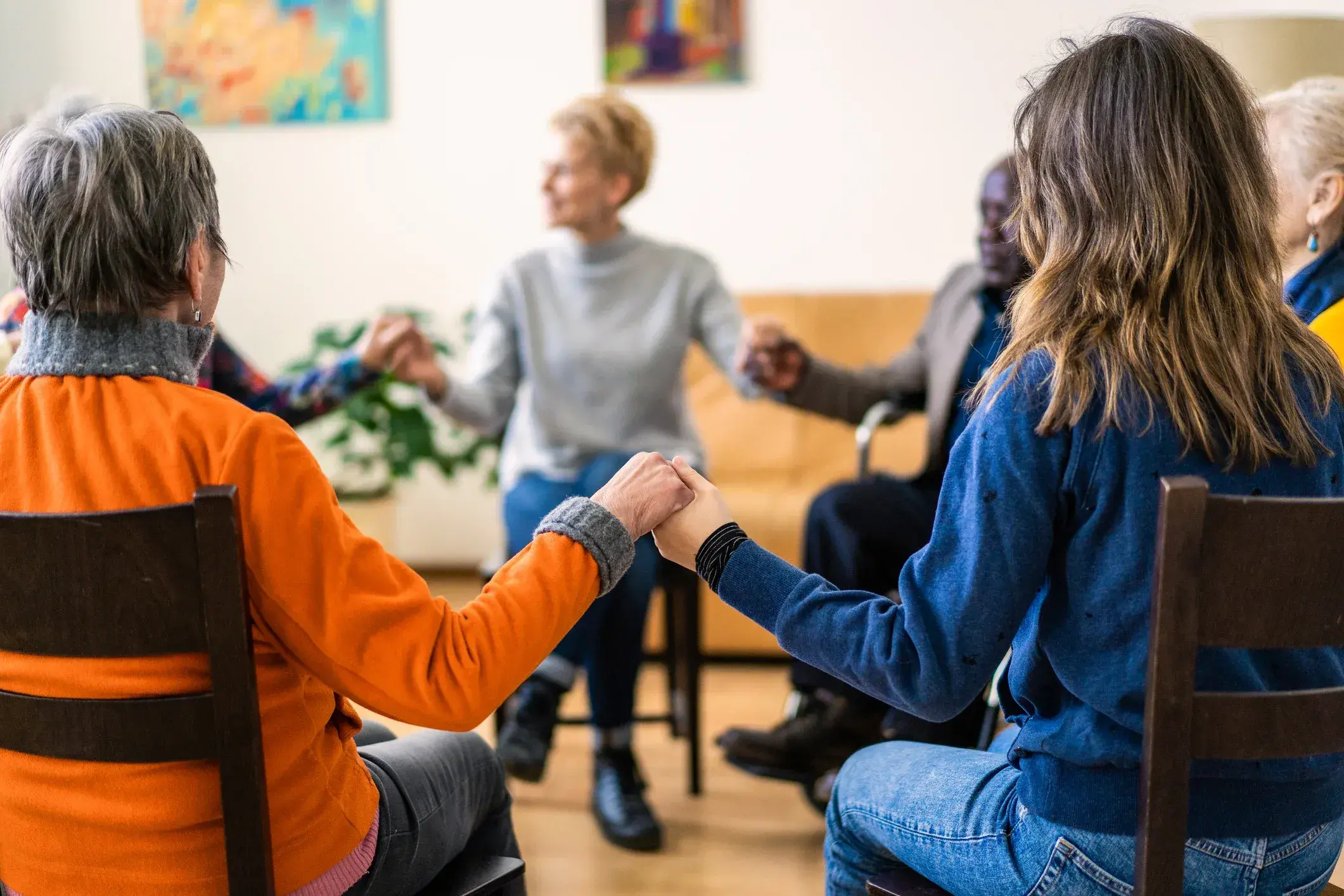 a group of seated adults holding hands